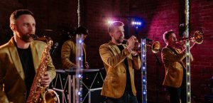 Live photo of The Vibrations UK DJ Live act playing trumpets and saxophone.